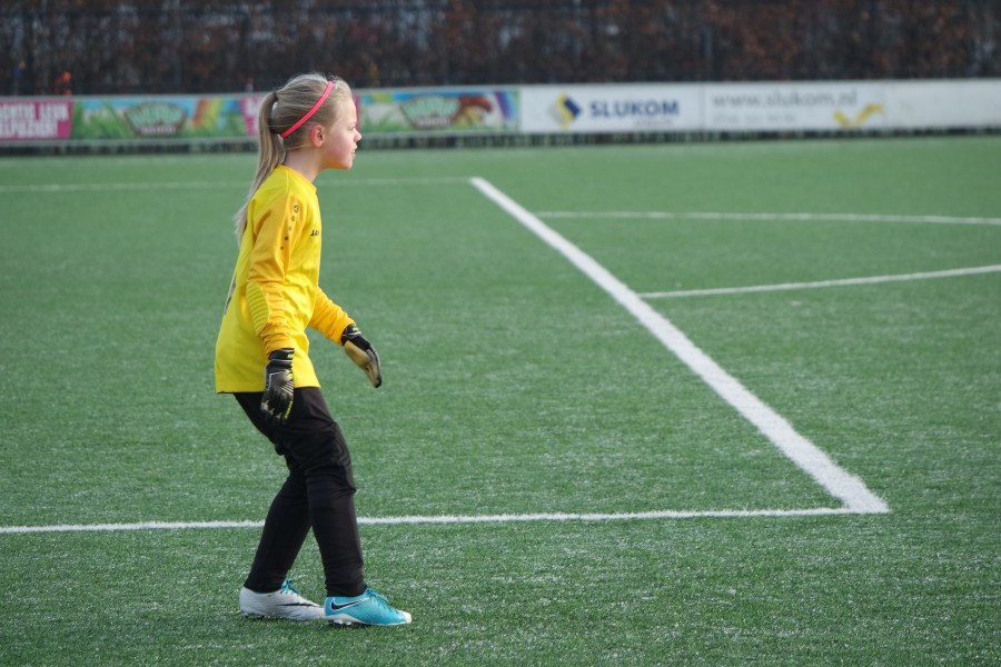 Niña jugando de portera al fútbol